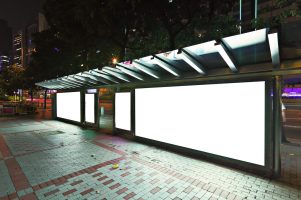 Blank billboard on bus stop at night