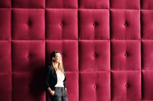 Young Business Woman Standing Against Burgundy Wall Panels