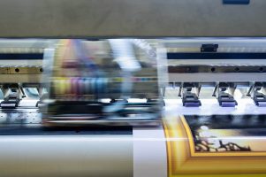 print-mari-dimensiuni - industrial-printer-printing-an-image-with-gold-fra